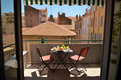 a table with a plate of fruit on a balcony at AzurAppart 3-rooms Cannes Carnot in Cannes