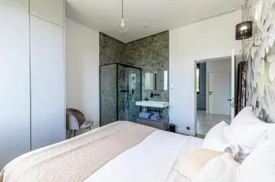 a bedroom with a white bed and a bathroom at Luxurious Villa with heated pool 6BR-12p - Cannes in Cannes
