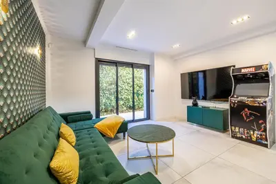 a living room with a green couch and a video game at Luxurious Villa with heated pool 6BR-12p - Cannes in Cannes