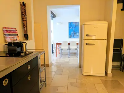 a white refrigerator in a kitchen with a table at Citilet 4 Duplex, funky with large terrace in Cannes