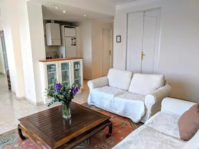 a living room with a vase of flowers on a coffee table at Citilet 6 Bright, open-plan with large terrace in Cannes