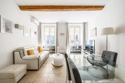 a living room with a couch and a glass table at LE MEYNADIER lumineux dans le centre historique, proche des plages et Palais in Cannes