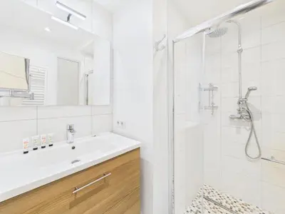 a white bathroom with a sink and a shower at LE MEYNADIER lumineux dans le centre historique, proche des plages et Palais in Cannes