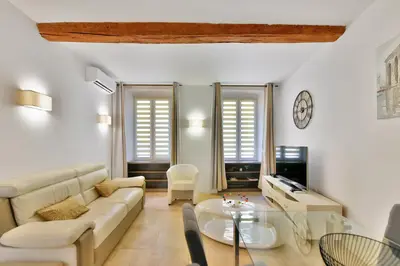 a living room with a couch and a table at LE MEYNADIER lumineux dans le centre historique, proche des plages et Palais in Cannes