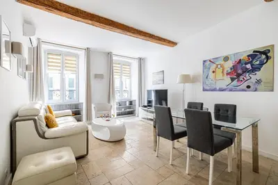 a white living room with a table and chairs at LE MEYNADIER lumineux dans le centre historique, proche des plages et Palais in Cannes