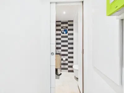 a bathroom with a white toilet and a black and white wall at LE MEYNADIER lumineux dans le centre historique, proche des plages et Palais in Cannes