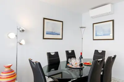 a dining room with a glass table and black chairs at Palm Beach 3 chambres in Cannes
