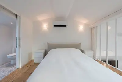 a white bedroom with a large bed and a toilet at Duplex Cannes plein Centre, Zone Piétonne, 2 Chambres in Cannes