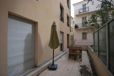 a patio with a wooden table and chairs on a balcony at Vieux Port One Bedroom Apartment A05 in Cannes