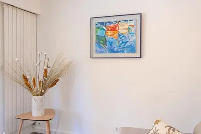 a vase on a table with a picture on a wall at C9 - 2 BDR 10 min Palais Festivals & Sea - AC, Parking & Balcony in Cannes