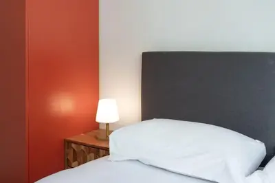 a bedroom with a white bed and a lamp at C9 - 2 BDR 10 min Palais Festivals & Sea - AC, Parking & Balcony in Cannes
