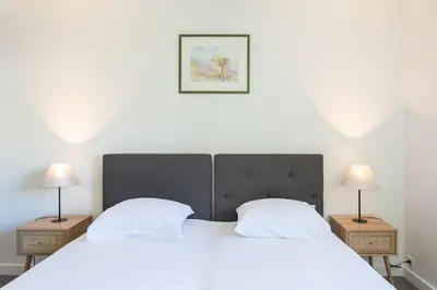 a white bed with two night stands and two lamps at C9 - 2 BDR 10 min Palais Festivals & Sea - AC, Parking & Balcony in Cannes