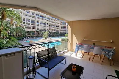 a balcony with a table and chairs and a swimming pool at WOW* mer/piscine/climat/parking in Cannes