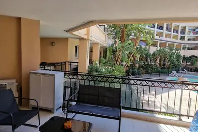 a balcony with a chair and a table and a building at WOW* mer/piscine/climat/parking in Cannes