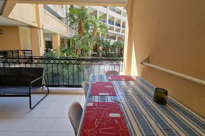 a long table in a room with a balcony at WOW* mer/piscine/climat/parking in Cannes