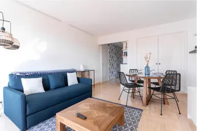 a living room with a blue couch and a table at Cocoon with garden near the sea in Cannes