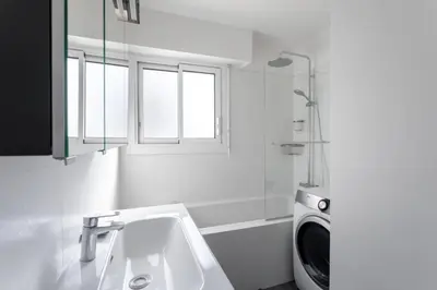 a bathroom with a sink and a washing machine at Cocoon with garden near the sea in Cannes