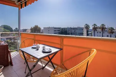 a table and chairs on a balcony with a view at Cocoon with garden near the sea in Cannes