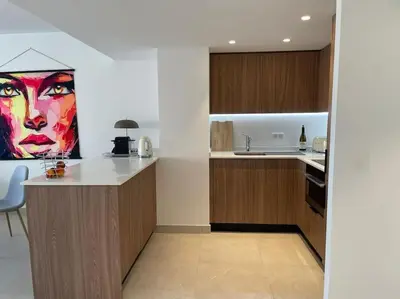 a kitchen with a painting of a woman on the wall at Paca properties -EC14- Appartements T2 - Cannes in Cannes