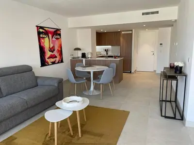 a living room with a couch and tables and a kitchen at Paca properties -EC14- Appartements T2 - Cannes in Cannes