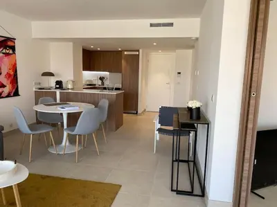a living room with a table and chairs and a kitchen at Paca properties -EC14- Appartements T2 - Cannes in Cannes
