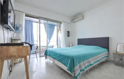 a bedroom with a bed and a desk and window at 1 Bedroom Awesome Apartment In Cannes in Cannes