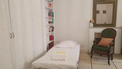 a room with a bed and a chair and a mirror at Bel Appartement Typique proche du Palais et Plages in Cannes