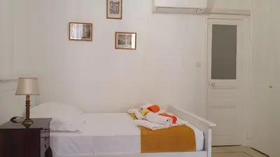 a white bedroom with a bed with shoes on it at Bel Appartement Typique proche du Palais et Plages in Cannes