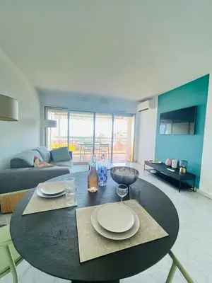 a living room with a table with plates on it at Les yeux dans le bleu, Cannes Vue mer in Cannes