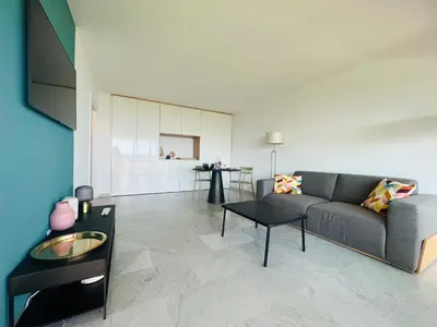 a living room with a couch and a table at Les yeux dans le bleu, Cannes Vue mer in Cannes
