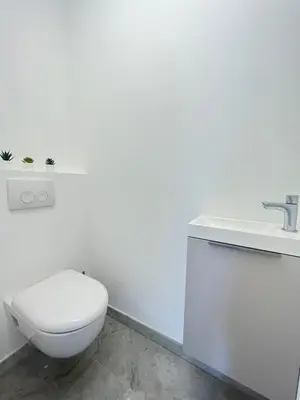 a white bathroom with a toilet and a sink at Les yeux dans le bleu, Cannes Vue mer in Cannes