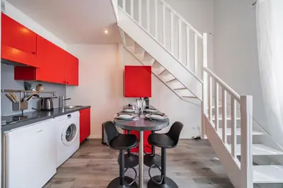 a kitchen with red cabinets and a table with chairs at Hypercentre - Palais - Croisette - Suquet - AY in Cannes