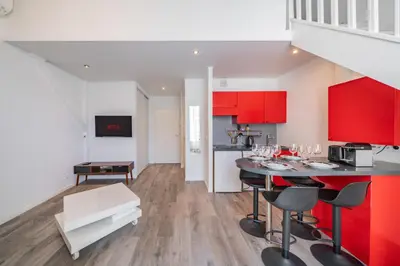 a kitchen with red cabinets and a table with chairs at Hypercentre - Palais - Croisette - Suquet - AY in Cannes