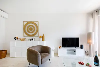 a living room with a chair and a tv at Royal Palm YourHostHelper in Cannes