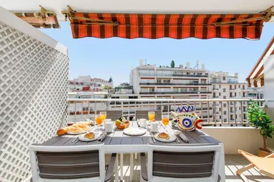 a table with food and drinks on a balcony at Royal Palm YourHostHelper in Cannes