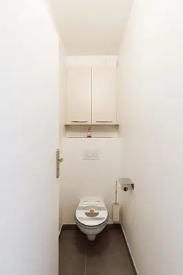 a bathroom with a toilet and a white cabinet at Royal Palm YourHostHelper in Cannes