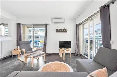 a living room with a couch and a tv at LE VERSAILLES plaisir et confort en centre-ville, pour séjours en famille ou business in Cannes