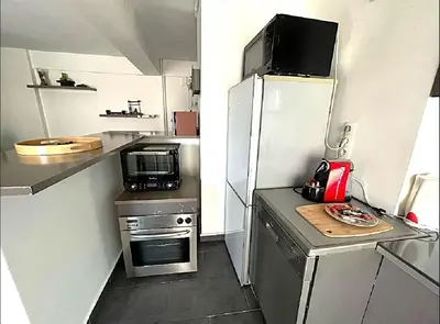 a small kitchen with a refrigerator and a microwave at LE VERSAILLES plaisir et confort en centre-ville, pour séjours en famille ou business in Cannes