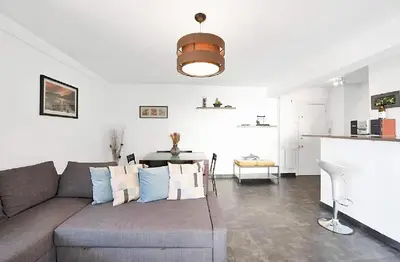 a living room with a couch and a table at LE VERSAILLES plaisir et confort en centre-ville, pour séjours en famille ou business in Cannes