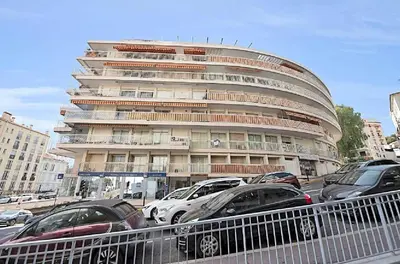 a large building with cars parked in front of it at LE VERSAILLES plaisir et confort en centre-ville, pour séjours en famille ou business in Cannes