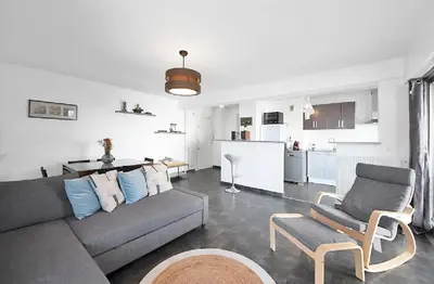 a living room with a couch and chairs and a kitchen at LE VERSAILLES plaisir et confort en centre-ville, pour séjours en famille ou business in Cannes