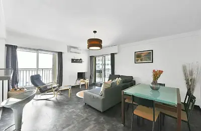 a living room with a couch and a table at LE VERSAILLES plaisir et confort en centre-ville, pour séjours en famille ou business in Cannes