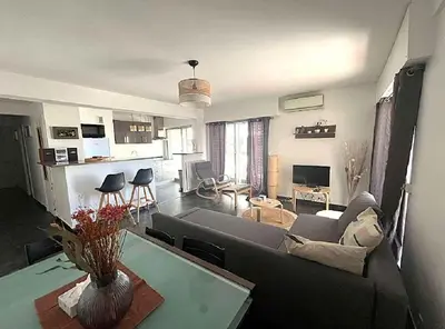 a living room with a couch and a table at LE VERSAILLES plaisir et confort en centre-ville, pour séjours en famille ou business in Cannes