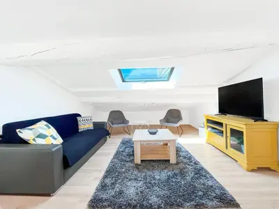 a living room with a blue couch and a tv at Le Bardot Croisette - Proche Palais & Mer - Climatisation in Cannes