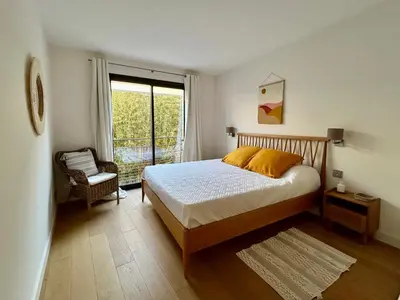 a bedroom with a bed and a window and a chair at Rumah Bali in Cannes