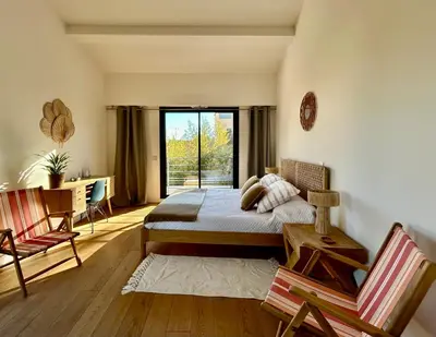 a bedroom with a bed and a desk and a window at Rumah Bali in Cannes