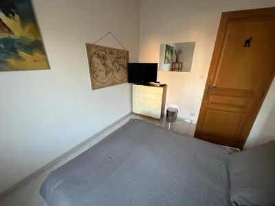 a bedroom with a bed and a wooden door at Chambre privé avec Sdb privative in Le Cannet