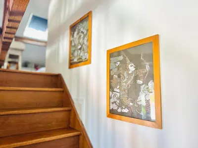 two framed pictures on a wall next to stairs at Place du Suquet - Terrasse - 3 Chambres - Parking in Cannes