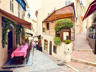 an alley with tables and chairs on a street at Place du Suquet - Terrasse - 3 Chambres - Parking in Cannes