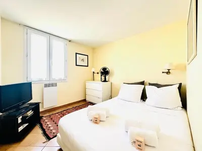 a bedroom with two beds and a flat screen tv at Place du Suquet - Terrasse - 3 Chambres - Parking in Cannes